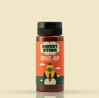 Bottle of Sweet Sting Space Jam chili jam on a beige background
